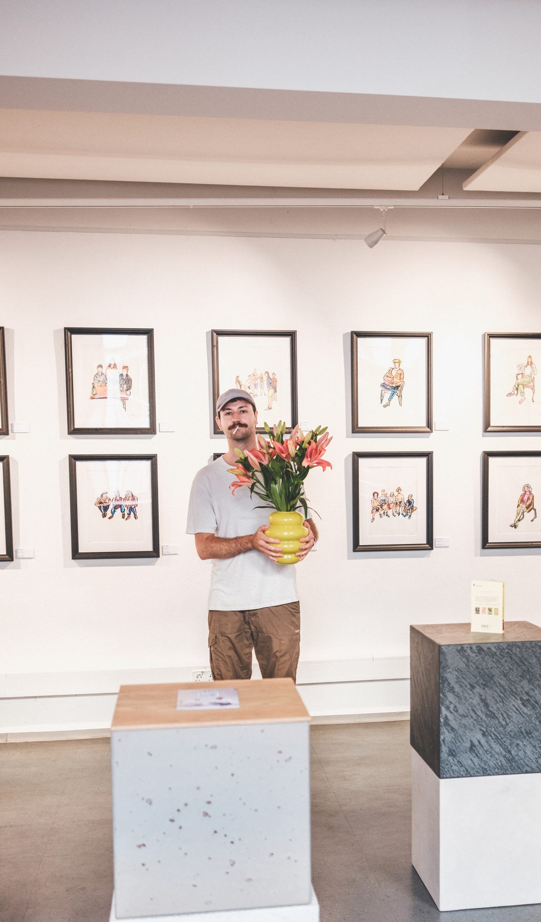Lukas Bärmann mit Blumenvase in der Ausstellung